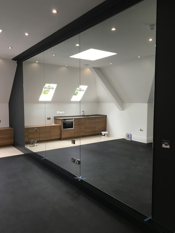 Frameless glass partition in loft conversion by Brentford glaziers